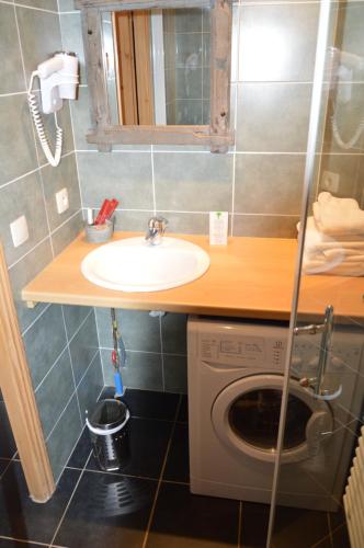 a bathroom with a sink and a washing machine at Le Relais Du Mont Blanc in Magland