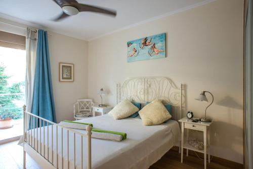 um quarto com uma cama com um berço e uma janela em Modern Apartment with sea view in Saronida em Anavissos