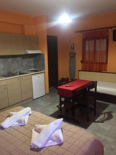 a kitchen with a red table and a kitchen with a sink at Aphrodite in Keramotí