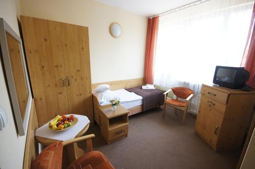 a hotel room with a bed and a table with a bowl of fruit at Rysy in Bukowina Tatrzańska