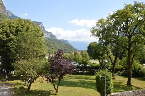 a park with trees and mountains in the background at Le Relais Du Mont Blanc in Magland