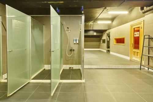 a bathroom with a shower with a glass door at Single inn- KAOHSIUNG LINSEN in Kaohsiung