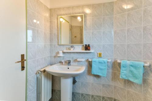 a bathroom with a sink and a mirror and blue towels at Apartments Redenta in Vabriga