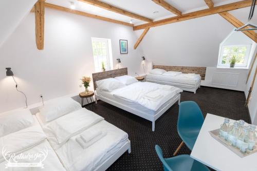 ビトゥフにあるPokoje hotelowe Nad jeziorem Jelenのベッド2台、テーブル、椅子が備わる客室です。