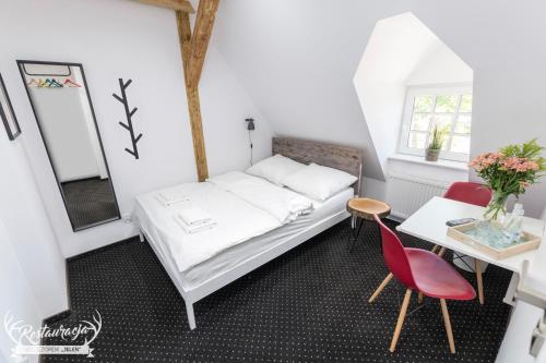 a bedroom with a bed and a table and a mirror at Pokoje hotelowe Nad jeziorem Jelen in Bytów