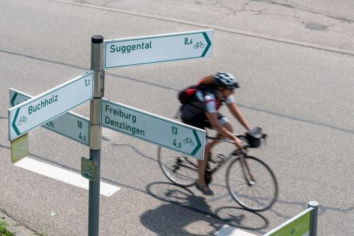 a person riding a bike past a street sign at Hotel Suggenbad in Waldkirch
