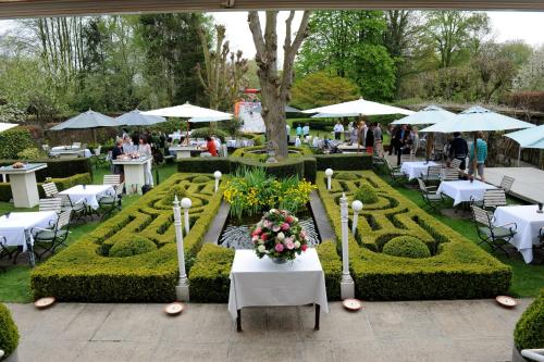 a garden with tables and chairs and a table with flowers at Hotel Geerts in Westerlo
