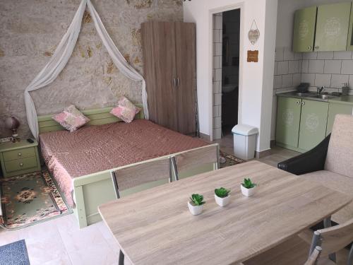 デミェンにあるSzitakötő Apartmanのベッドルーム1室(ベッド1台、鉢植えの植物が置かれたテーブル付)