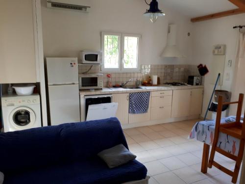 een keuken met een blauwe bank in een kamer bij Mini Villa à 100m de la mer avec prise de recharge élec privative in Sari Solenzara