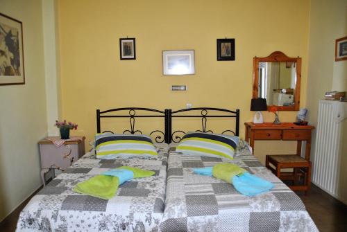 a bedroom with a bed with green and blue pillows at Kalokenti Studios in Aegina Town