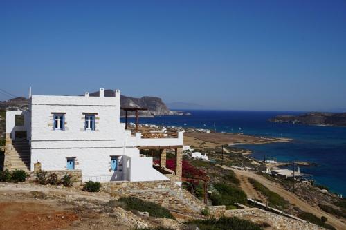 a white house on top of a hill with the ocean at Antiparos Vibes in Agios Georgios