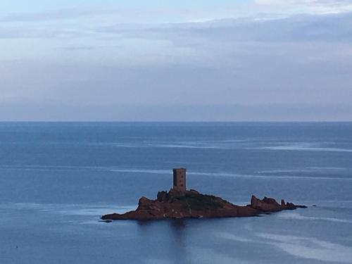 an island in the ocean with a lighthouse on it at Villa ALFONSA in Saint-Raphaël