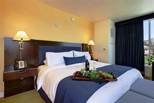 a hotel room with a bed with a tray of food on it at University Plaza Waterfront Hotel in Stockton
