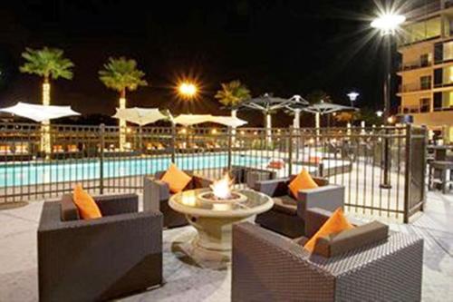a patio with chairs and a pool at night at University Plaza Waterfront Hotel in Stockton