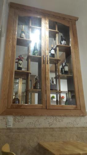 a wooden cabinet filled with lots of glass at Tomorrow Hostel Vũng Tàu - Tomorrow Homestay in Vung Tau