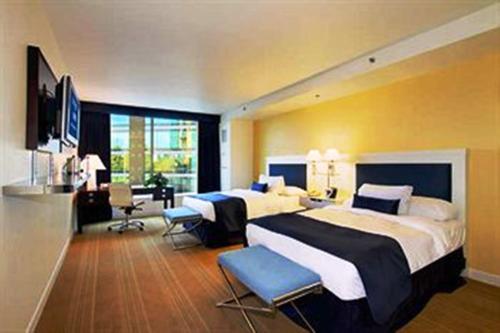 um grande quarto de hotel com duas camas e uma secretária em University Plaza Waterfront Hotel em Stockton