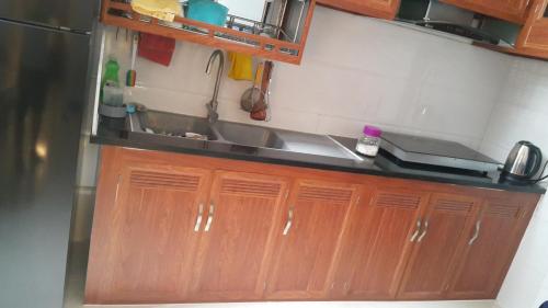 a kitchen with wooden cabinets and a sink at Tomorrow Hostel Vũng Tàu - Tomorrow Homestay in Vung Tau
