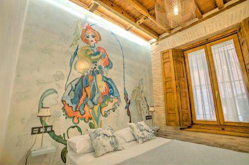 a bedroom with a large painting on the wall at Casa Meninas y Anillo Apartamentos Deluxe MeninasCollection in Toledo