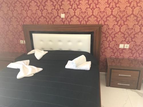 a bedroom with a black bed with white pillows at Floral Studios in Kefalos