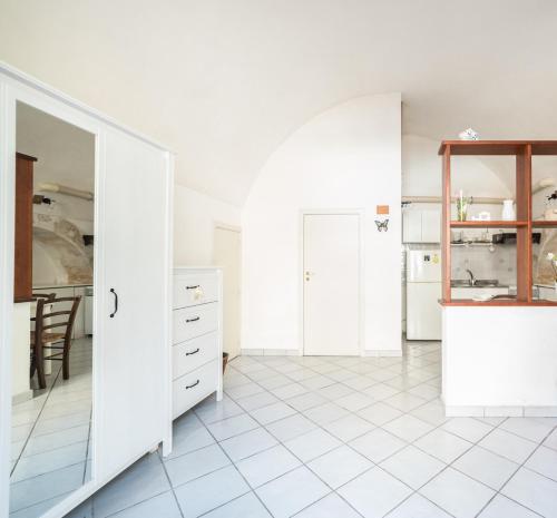 eine Küche mit weißen Schränken und weißem Fliesenboden in der Unterkunft Latte&Miele in Ragusa