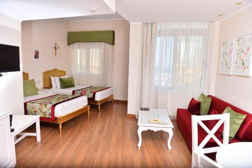 a hotel room with two beds and a couch at San Giovanni Stanly Hotel in Alexandria