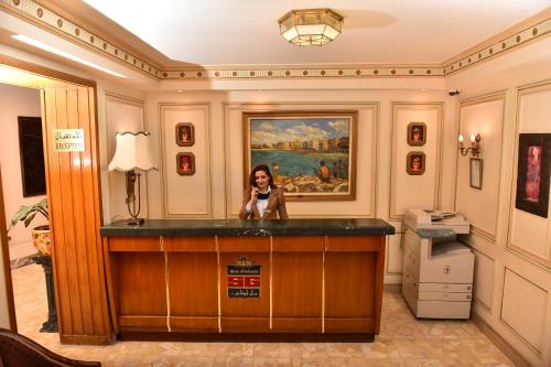a woman sitting at a bar in a hotel room at San Giovanni Stanly Hotel in Alexandria