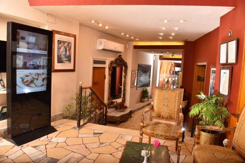 a living room with orange walls and a couch and chairs at San Giovanni Stanly Hotel in Alexandria
