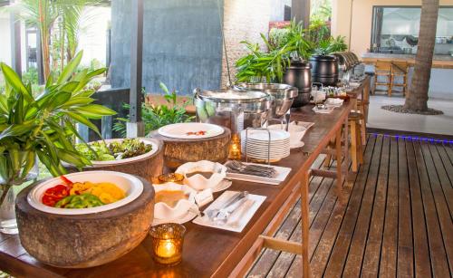 een lange houten tafel met kommen eten erop bij Islanda Hideaway Resort in Krabi town