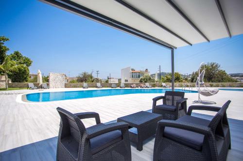a patio with chairs and a table and a pool at Madison Boutique, Faliraki in Faliraki