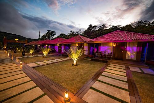 a row of houses with lights in the yard at DATA Resort by Della Adventure in Lonavala
