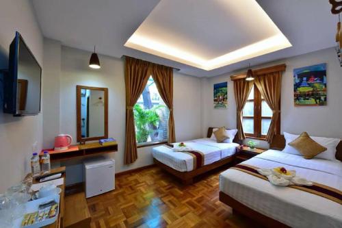 um quarto de hotel com duas camas e uma televisão em Northern Breeze Hotel em Bagan
