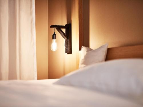a bedroom with a bed with a light on the wall at Hotel Zugbrücke Grenzau GmbH in Höhr-Grenzhausen