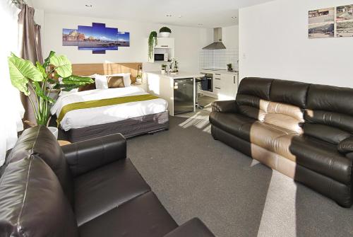 Un dormitorio con una cama y un sofá y una cama y una sala de estar. en Newlands Court Motel, en Wellington