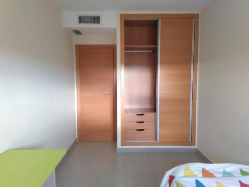 um quarto com um armário e uma porta de madeira em Apartamento en residencial arenas San Juan em Alicante