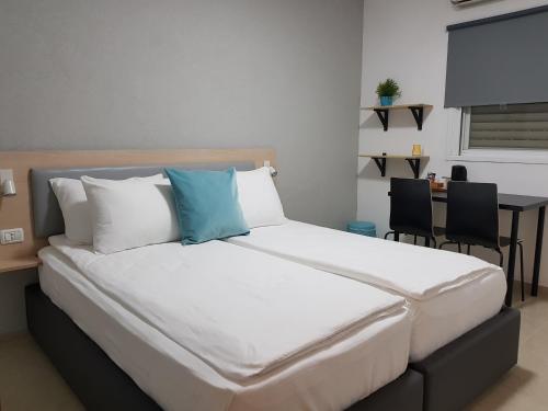 a bed in a room with a table and chairs at Airport Guest House - One-Way Free Shuttle in Or Yehuda