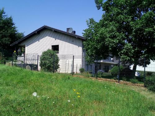 a white house on a hill next to a field at Appartement Willmeroth in Königswinter