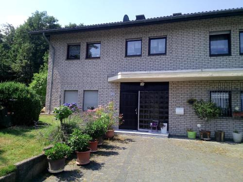 a brick house with potted plants in front of it at Appartement Willmeroth in Königswinter