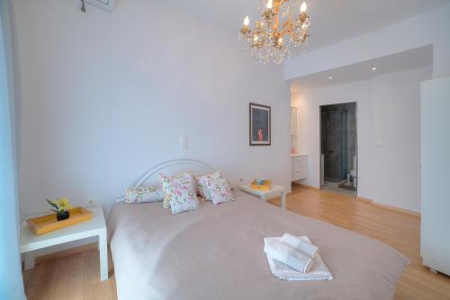 a bedroom with a large bed and a chandelier at Apartment in Glyfada Center in Athens