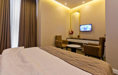a hotel room with a bed and a table and chairs at Aksent Hotel in Baku