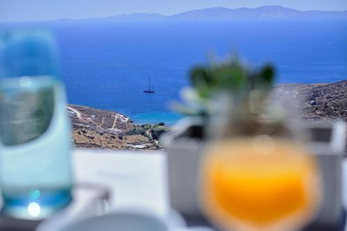a view of the ocean with a boat in the distance at Living Theros Luxury Suites in Kardiani