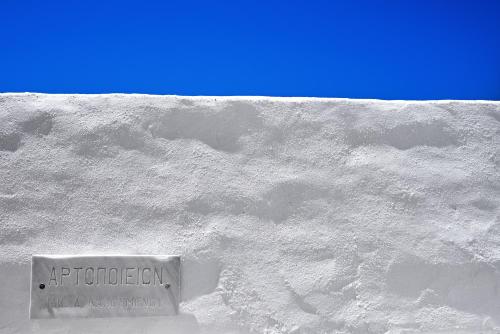 a sign on the side of a white wall at Living Theros Luxury Suites in Kardiani