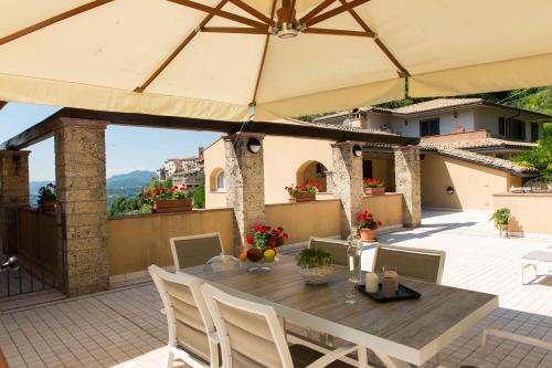 a patio with a table and chairs and an umbrella at La Fonte Su in Canterano