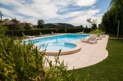 - une piscine avec des chaises longues et des chaises dans la cour dans l'établissement Quinta Da Fontinha, à Celorico de Basto