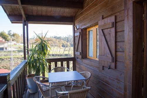 a table and chairs on the balcony of a cabin at Quinta Da Fontinha in Celorico de Basto