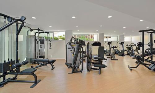 a gym with a row of treadmills and exercise bikes at INNSiDE by Meliá Calviá Beach in Magaluf