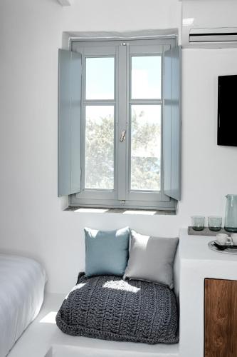 a white room with a window and a rug at Living Theros Luxury Suites in Kardiani