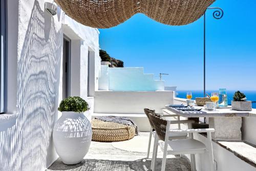 a patio with a table and chairs and a vase at Living Theros Luxury Suites in Kardiani