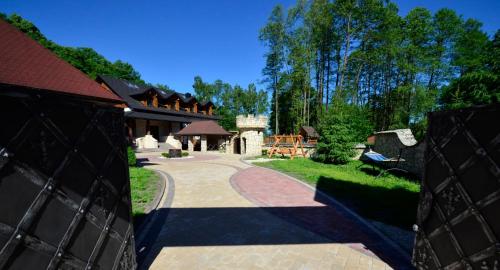 a driveway leading to a house with a pavilion at Ranczo Czerwony Młyn in Zdów