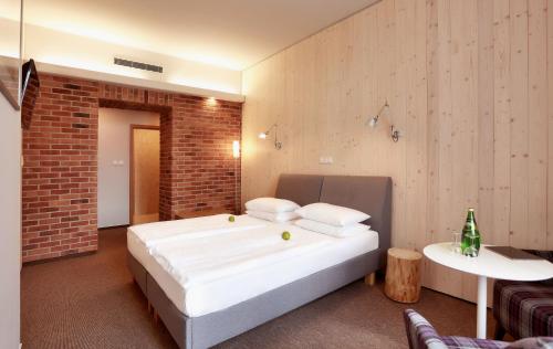 a bedroom with a large bed and a brick wall at Absolutum Wellness Hotel in Prague