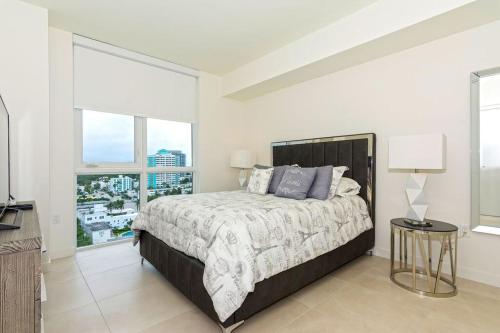 a bedroom with a bed and a large window at Departamento en Tiffany House Fort Lauderdale beach Miami in Fort Lauderdale